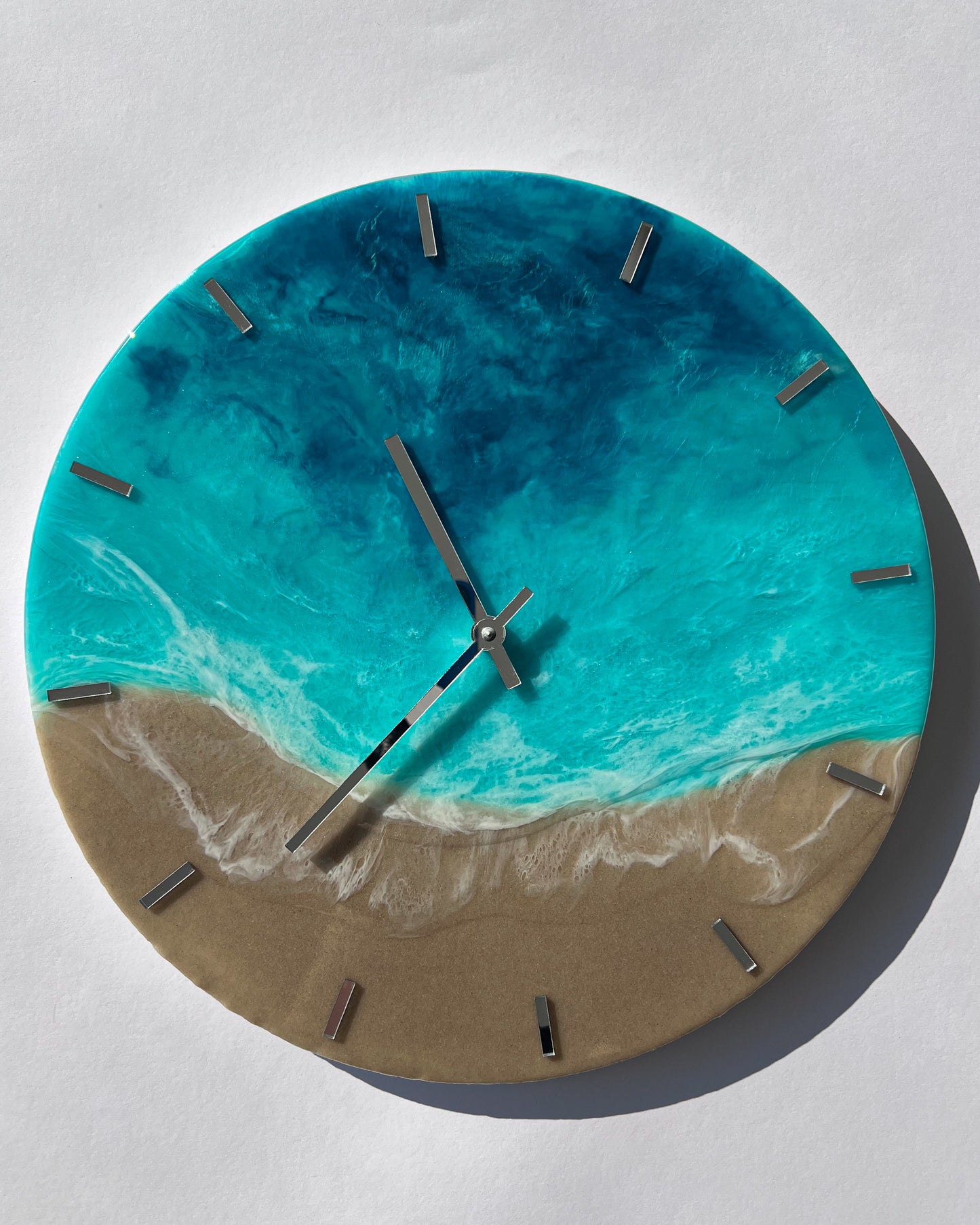 Epoxigyanta falióra türkiz és mélykék óceánhatású mintázattal, fehér habos hullámokkal és homokszínű parttal, közelről fotózva.