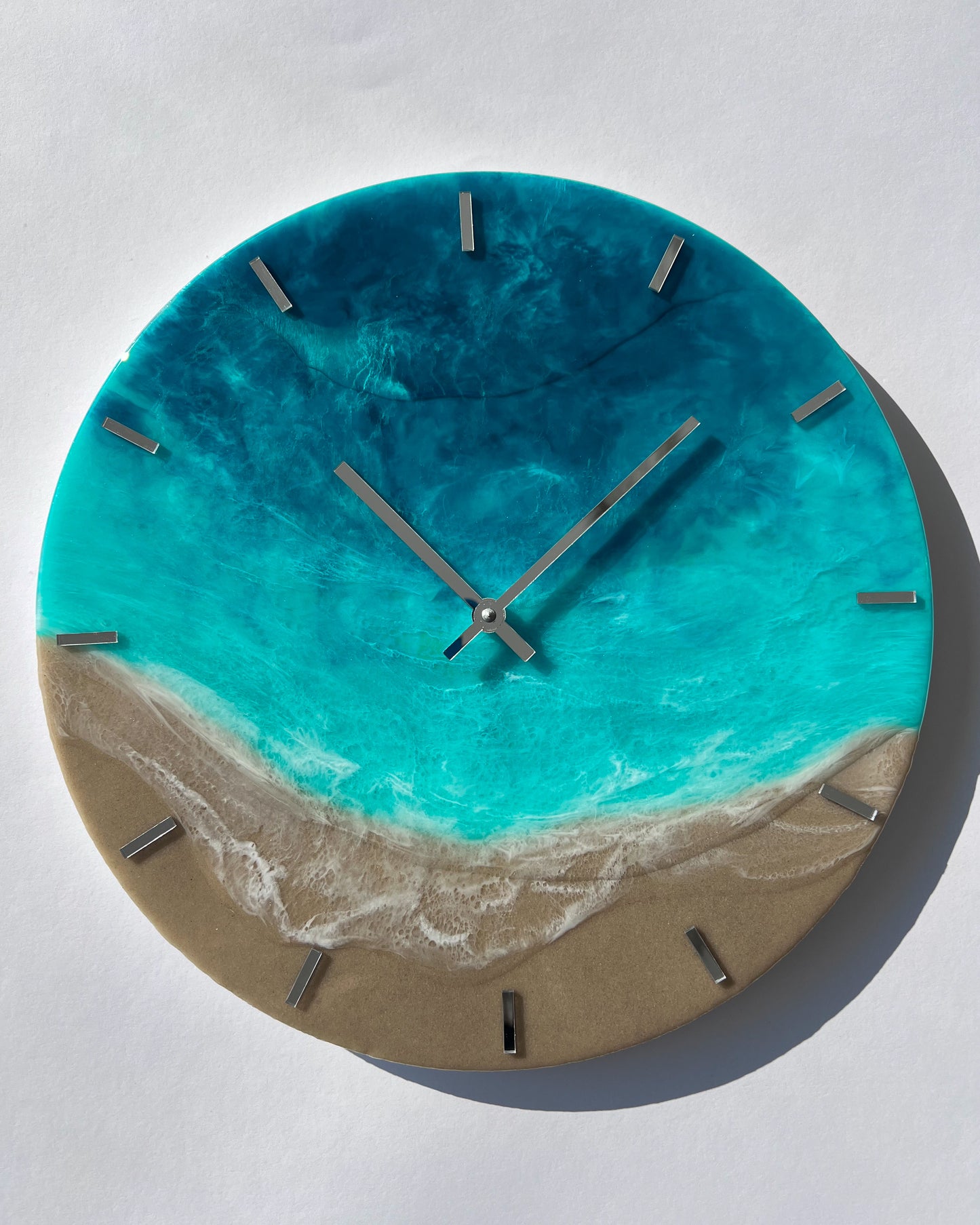 Epoxigyanta falióra türkiz és mélykék óceánhatású mintázattal, fehér habos hullámokkal és homokszínű parttal, közelről fotózva.