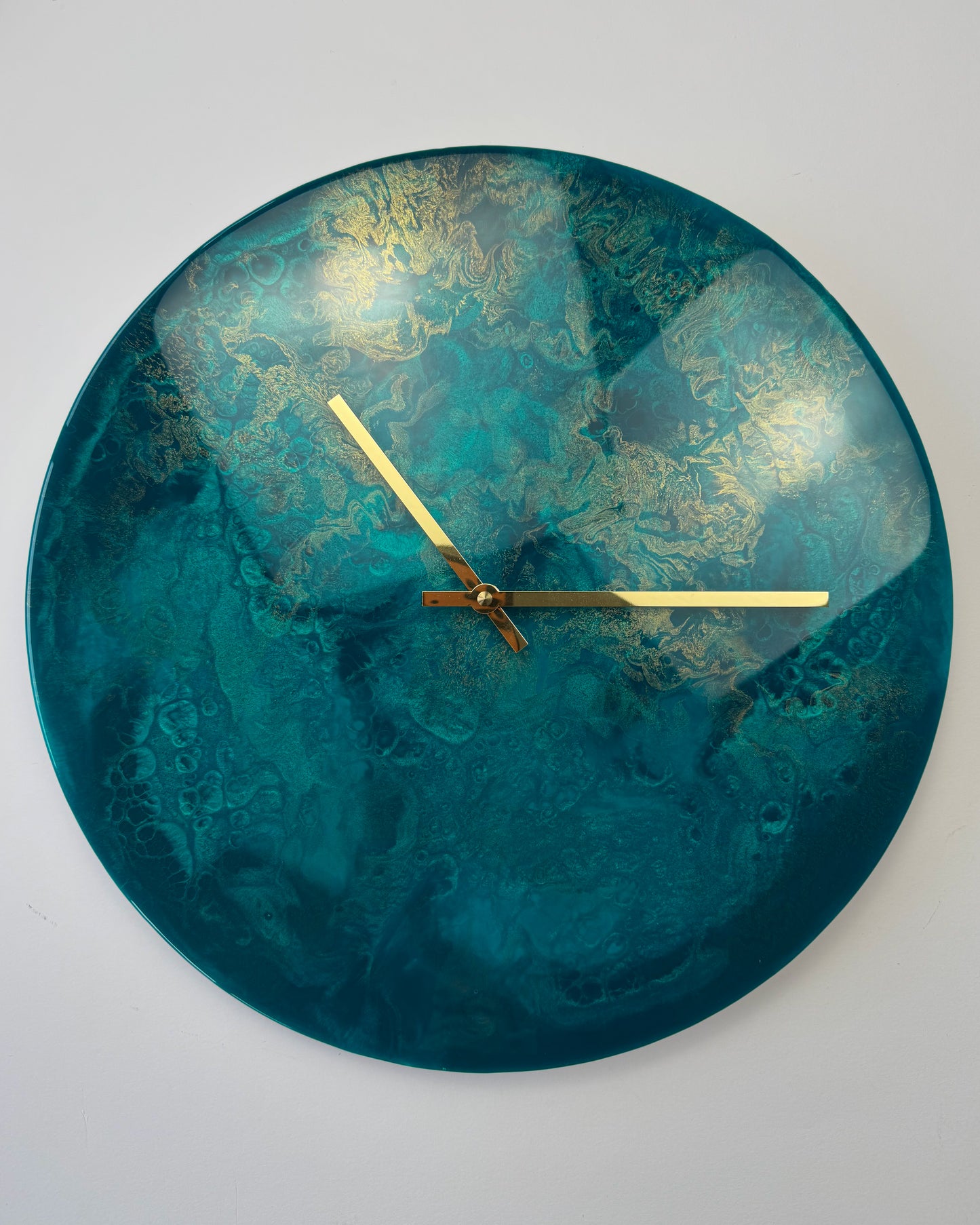 Türkizkék galaxis hatású, magasfényű, kerek falióra epoxigyantából.